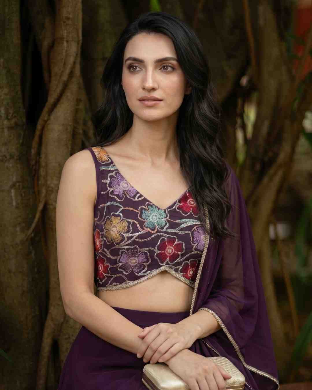 Editorial close-up of Trishika Vaidya in the QISSA burgundy pre-draped farewell saree by a banyan tree for KapdeWali